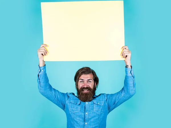 Above all in service. happy bearded man with empty paper sheet. barbershop service. concept of advertisement. brutal man with beard and moustache. search for a job. place for copy space