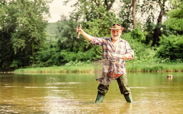 Ora inizia il vero divertimento. weekend estivo. pescatore con canna da pesca. uomo maturo pesca. Pothunter. uomo cattura il pesce. Pescatore barbuto in pensione. pesca d'altura. attività sportiva e hobby. Esche di trota — Foto Stock