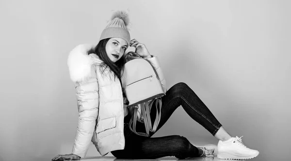 time to rest. girl in puffed coat. faux fur fashion. warm winter clothing. shopping. woman in beanie hat with backpack. flu and cold season. Leather bag fashion. happy winter holidays