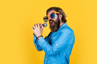 Yüksek bir not al. Mikrofonlu vahşi erkek hippi. vokal okulu. En sevdiği müzik tarzı. Müzik konsepti. Oyuncu eğleniyor. Komik parti gözlüklü olgun sakallı adam şarkı söyler.