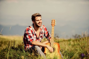 Hayalperest gezgin. Seyahat tutkusu konsepti. İlham verici bir doğa. İlham arayan bir müzisyen. Yaz tatili doğada var. Tek başına iyi vakit geçirdin. Huzurlu bir ruh hali. Gitarlı adam doğayı düşünüyor.