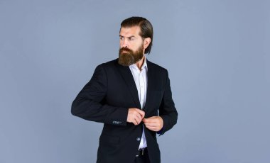 Mükemmel sakallı ve bıyıklı acımasız bir iş adamı. Ceketli gerçek patron. Olgun adam ciddi görünüyor. Güven ve karizma. Yakışıklı adam ofis kıyafeti giyer. Erkek güzelliği ve moda