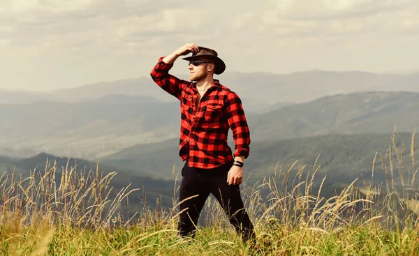 Futuro. vaquero en sombrero al aire libre. hombre en el paisaje de montaña. camping y senderismo. aventura de viaje. moda hipster. concepto de campo. granjero en rancho. sexy macho hombre en a cuadros camisa —  Fotos de Stock