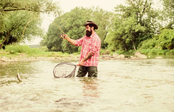 La pesca è stupefacente sport all'aperto ricreativo accessibile. hobby di pesca. La pesca fornisce quel collegamento con tutto il mondo vivente. Trova la pace della mente. Pesce trota pescatore barbuto cattura con rete — Foto Stock