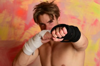 Siyah kemerli ve kollarında bandaj olan adam.