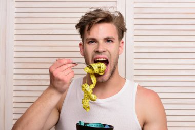 Adam ahşap arka planda erişte yiyormuş gibi yapıyor.