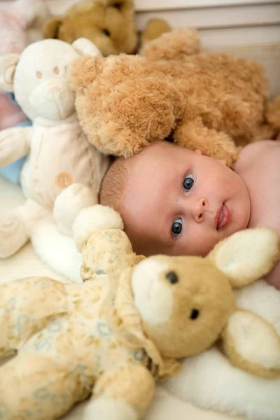 Bebé acostado junto a conejito beige. Bebé niño con juguetes suaves — Foto de Stock