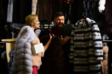 Sakallı satıcı ve kadın kürklü palto alır..