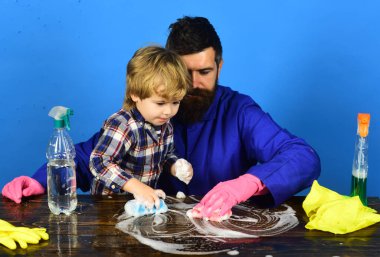 Babası tahta masayı temizleyen bir çocuk. Aile zamanı kavramı.