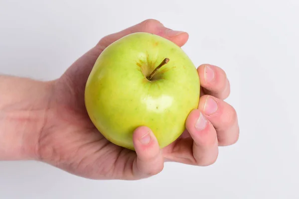 Männliche Hand hält hellgrünen Apfel. Apple in heller Farbe — Stockfoto