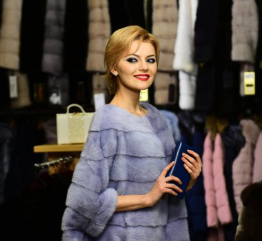 Lüks ve moda. Neşeli yüzlü kız kürklü ceket giyiyor.