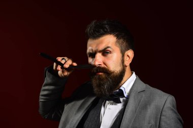 Uzun sakallı adam jilet yerine bıçak tutuyor. İşadamı