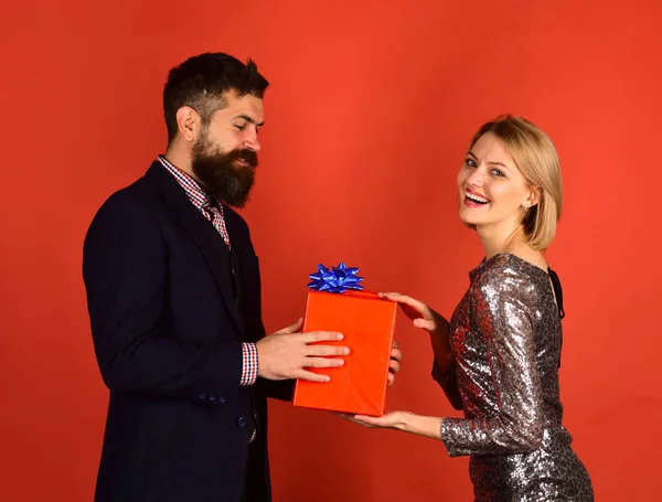 Пара влюбленных делится подарками на красном фоне. — стоковое фото
