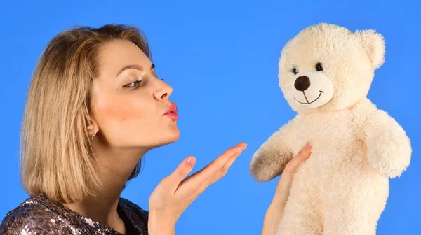 Wanita memegang boneka beruang di latar belakang biru. — Stok Foto