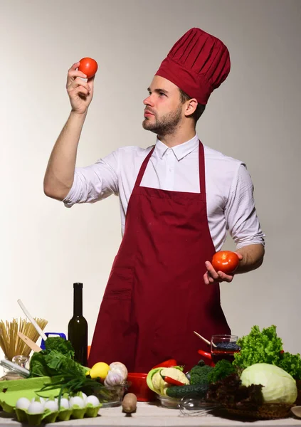 Hombre con barba con tomates sobre fondo gris. —  Fotos de Stock