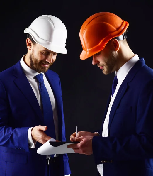 Ingenieros con caras sonrientes miran documentos. — Foto de Stock