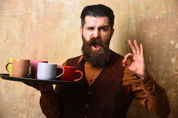 Cameriere con diverse tazze da tè sul vassoio. Uomo con la barba — Foto Stock