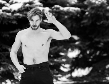 Kışın doğal arka planda yakışıklı, kaslı bir adam.