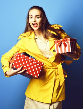 Mavi stüdyo arka planında askısı olan gülümseyen renkli kız.