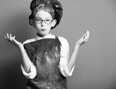 Kırmızı stüdyo arka planında lekeli aşçı çocuk.