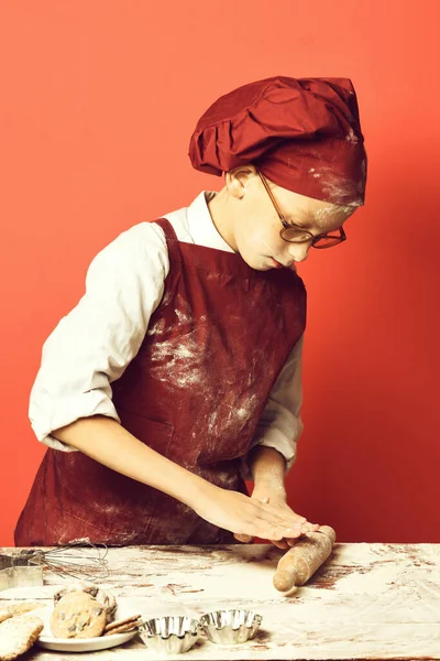 Manchado bonito cozinheiro chef menino no vermelho estúdio fundo — Fotografia de Stock