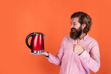 En iyi kalite. Sıcak içecek iç. Mutfak gereçlerini sunuyorum. İyi kalite. Sakallı, çay içen olgun bir hippi. Elektrikli su ısıtıcısı olan vahşi bir adam. Gününü ısıt. Sakallı adam