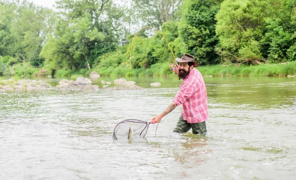 Trae la red de pesca. pescador con caña de pescar. fin de semana de verano. Pesca de caza mayor. hombre maduro pesca con mosca. hombre pescando peces. pasatiempo y actividad deportiva. Pothunter. barbudo pescador en agua —  Fotos de Stock