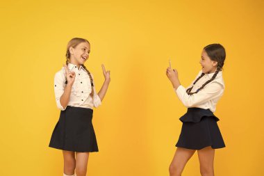 Çok güzeller. Okul üniformalı küçük kızlar. Okula dönüyorum. Eğitim blogu. Yeni teknoloji. Online eğitim. Bilgi günü. Akıllı telefonlu mutlu öğrenciler. Çocuklar fotoğraf çeker, arkadaşlık eder.