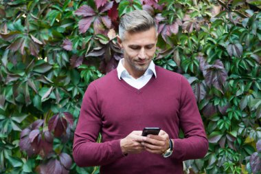 Gülümseyen adam akıllı telefonda mesaj yazıyor, iletişim.