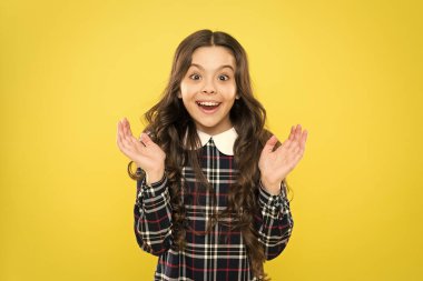 Harika haberlerim var. Mutlu gülümseyen çocuk portresi. Duygusal ifadeler. Sadece mutluyum. Küçük kız zarif damalı elbise. Çocuk uzun kıvırcık saçlı. Mutlu liseli kız üniforması. Çocukluk kavramı