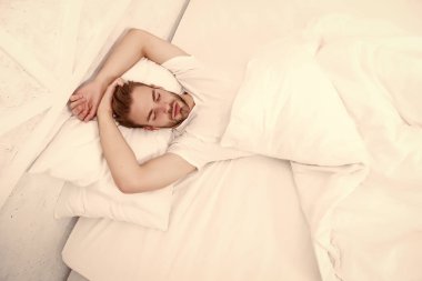 Sağlıklı uyku konsepti. Sağlıklı uyku alışkanlıklarını destekleyen ipuçları. Yatakta dinlenen yakışıklı adam. Düzenli olarak geceleri uyuyun. Yatmadan önce meditasyon gibi sakinleştirici aktiviteler üzerinde çalış