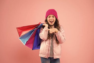 Kış alışverişi. Müşteri konsepti. Noel indirimi. Çocuk modası. Tatil alışverişi tasarrufu. Evden alışveriş. Alışveriş torbalı küçük bir kız. Satış ve indirimler. Mutlu çocuk. Yetenekli küçük kız
