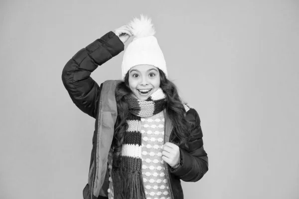 Wat een hoed. Gelukkig kind draagt warme hoed. Klein meisje glimlach in pompom hoed. Fashion accessoire voor de winter. Mode en stijl. Warme en stijlvolle muts voor koud weer — Stockfoto