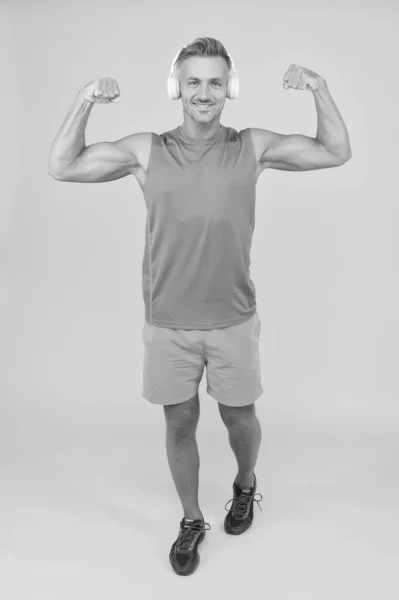 Hudba je moc. Šťastný muž opravit ruce žluté pozadí. Ten chlap má sílu svalů. Tělocvična oblečení a sportovní oblečení. Sílu a sílu. Výcvik na sílu. Fitness a sport. Zdravý životní styl — Stock fotografie