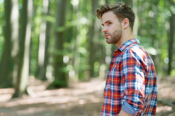 Hombre guapo viajar en madera de verano paisaje natural soleado al aire libre con camisa a cuadros en estilo casual, moda —  Fotos de Stock