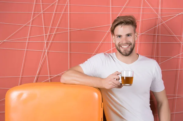 Sorriso de solteiro com bebida matinal na geladeira. Solteiro segurar xícara de chá ou café na geladeira retro em fundo rosa — Fotografia de Stock