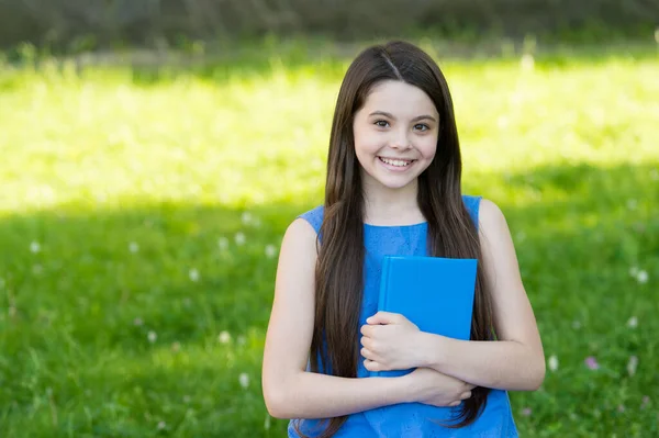 Kleines intelligentes Mädchen mit Buch im Freien sonniger Tag, Selbsterziehungskonzept — Stockfoto