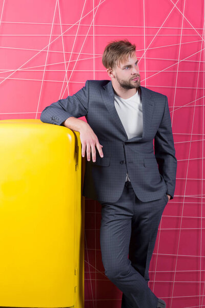 Бытовой холодильник "Яркий" - предмет интерьера. Винтажные бытовые приборы. Мужчина формальный элегантный костюм опирается на ретро-винтажный желтый холодильник. Холостяк элегантный парень думаю, что едят возле холодильника