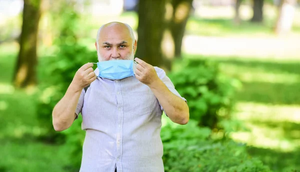 Kehidupan selama coronavirus terkunci. menikmati keindahan. Takut sakit. Strategi memerangi virus. Larangan mengunjungi tempat-tempat umum. Pria senior melepas masker medis. Orang tua berjalan di taman — Stok Foto