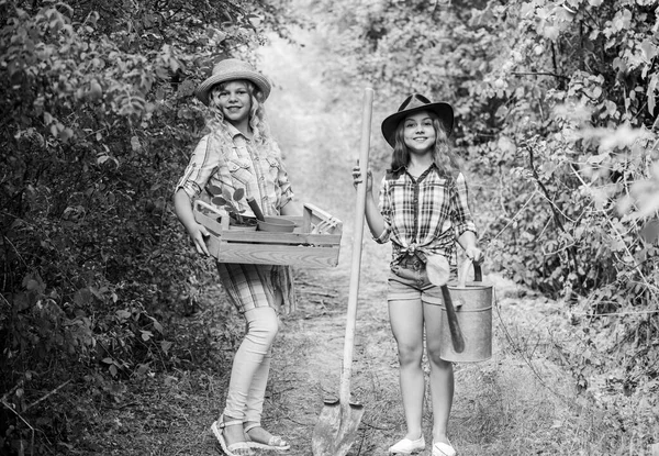 Imádunk kertészkedni. gazdálkodás és mezőgazdaság. Tavaszi vidék. Földi nap. nyári családi farm. ökológia és környezetvédelem. Kislányok farmerek a faluban. a gyermekek kertészeti eszközöket tartanak — Stock Fotó