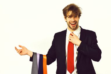 Sakallı, maço, şık takım elbiseli, kravatlı bir adam.