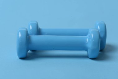 Mavi arkaplanda mavi plastik dambıllar