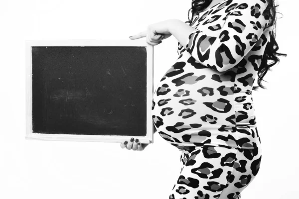 Mãos femininas de mulher grávida segurando placa preta — Fotografia de Stock