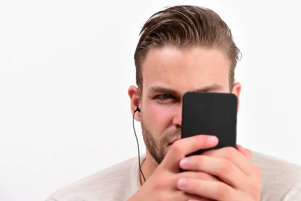 El hombre con la cara atenta mira el teléfono móvil. Concepto de entretenimiento —  Fotos de Stock