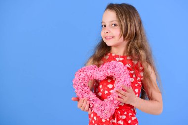 Mavi arka planda pembe kalp tutan mutlu kız