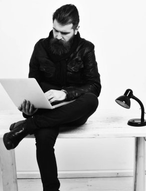 Masada dizüstü bilgisayarla oturan vahşi beyaz hippi.