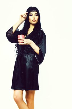 Siyah ipek elbiseyle fincanla poz veren seksi kız