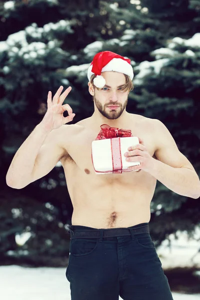 Hombre musculoso guapo con caja presente en invierno al aire libre — Foto de Stock