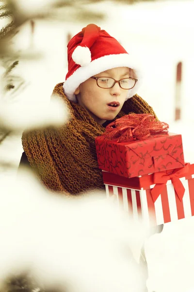 Kisfiú ajándék dobozok télen szabadban — Stock Fotó