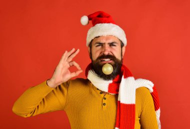 Kırmızı şapkalı Noel Baba tamam işareti gösteriyor. Sakallı adam